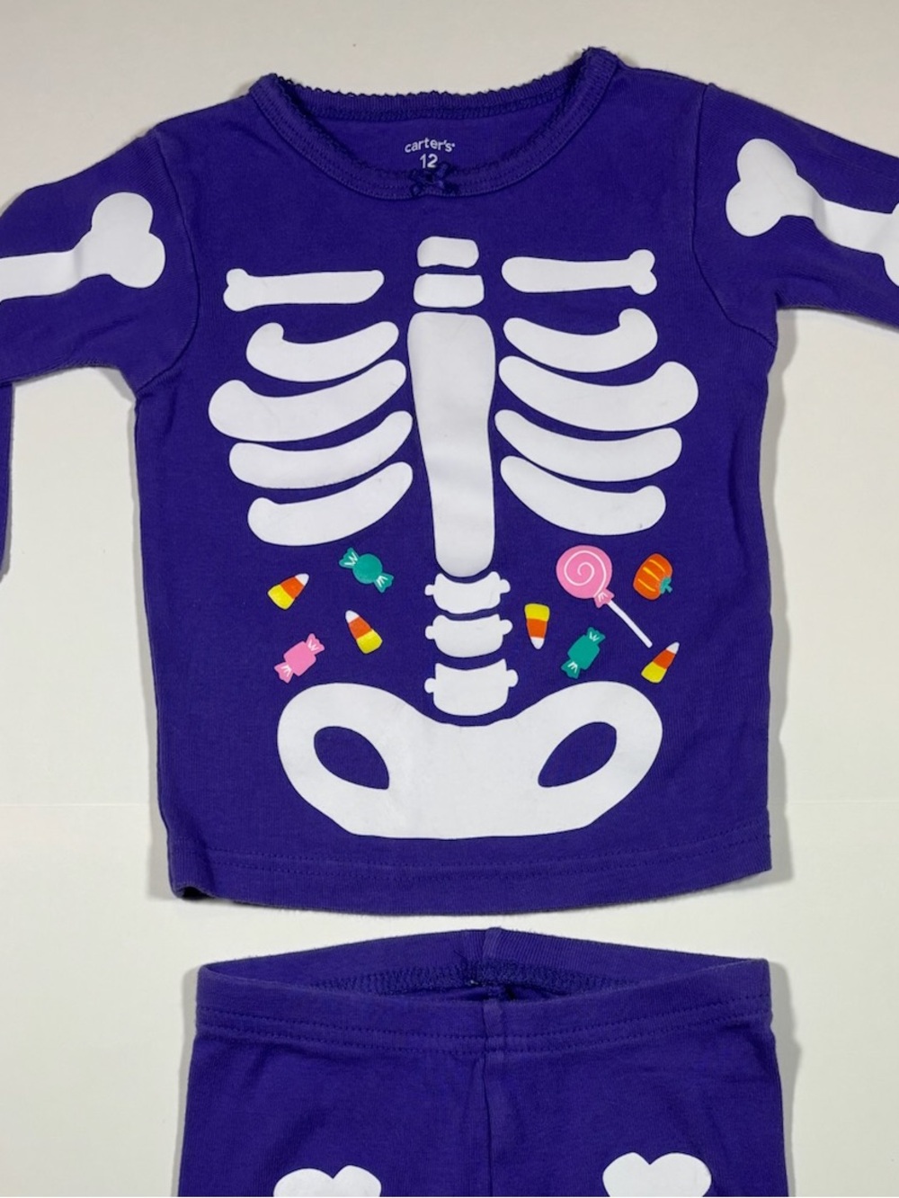 Carter’s 12 months snug-fitting purple Halloween pajamas skeleton with candy
